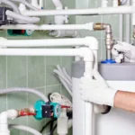plumber doing maintenance jobs water heating systems engineer controlling pipes boiler room 119782566